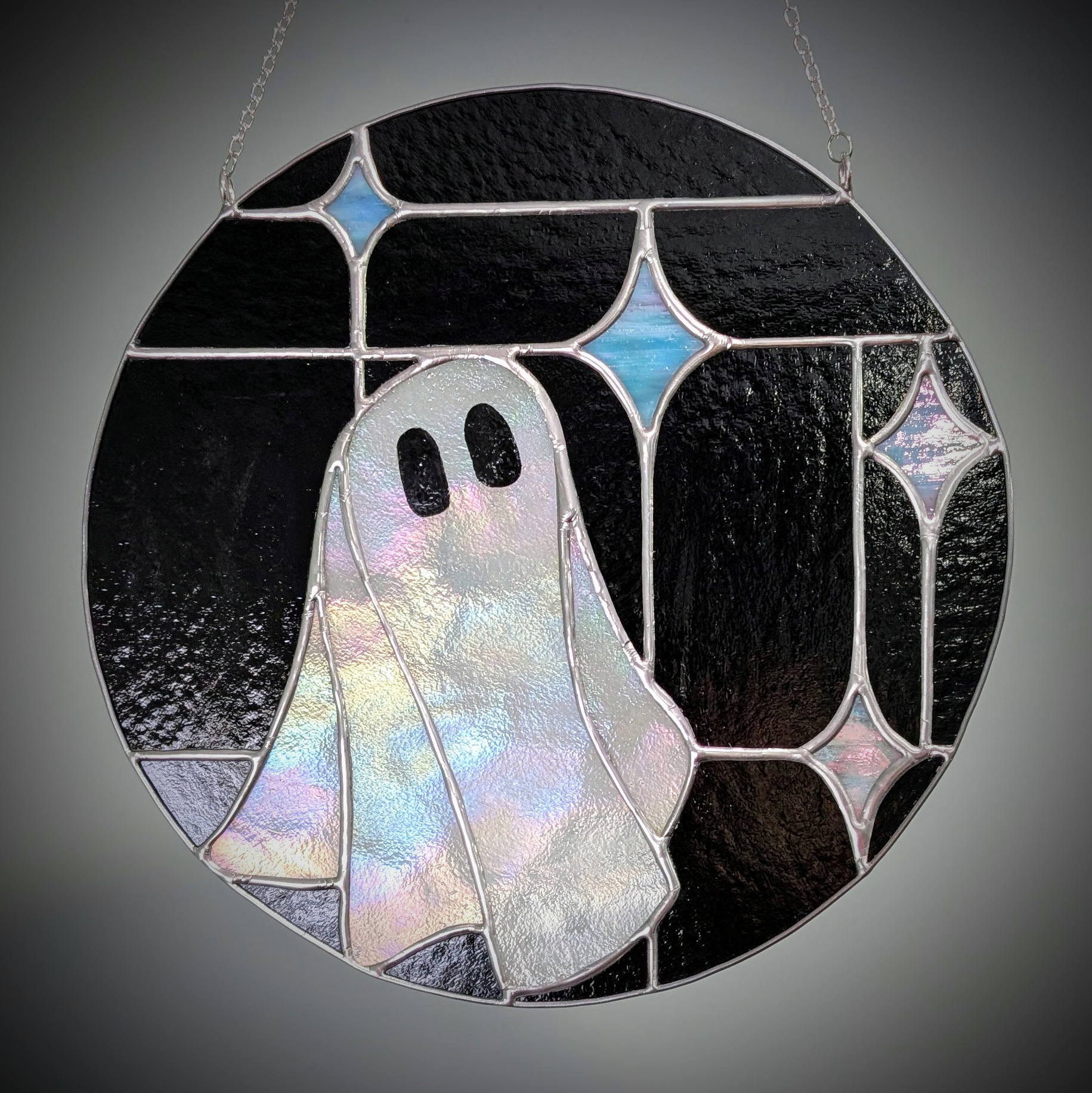 A black and sparkly stained glass ghost