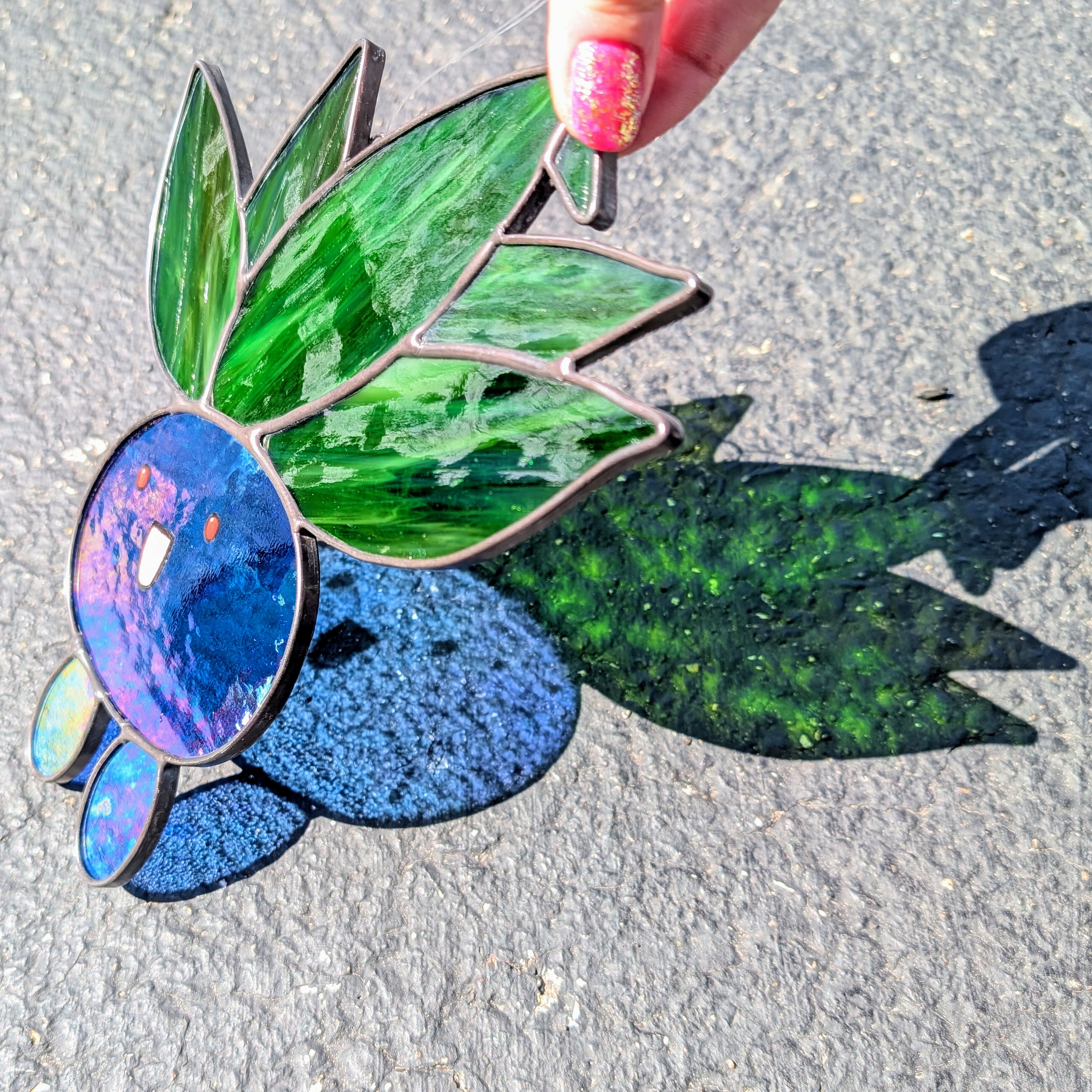 A blue and green stained glass oddish
